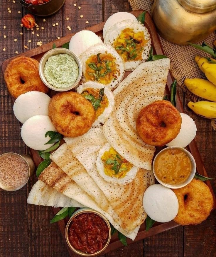 South Indian breakfast with idli, dosa, sambar, chutney, and coffee.