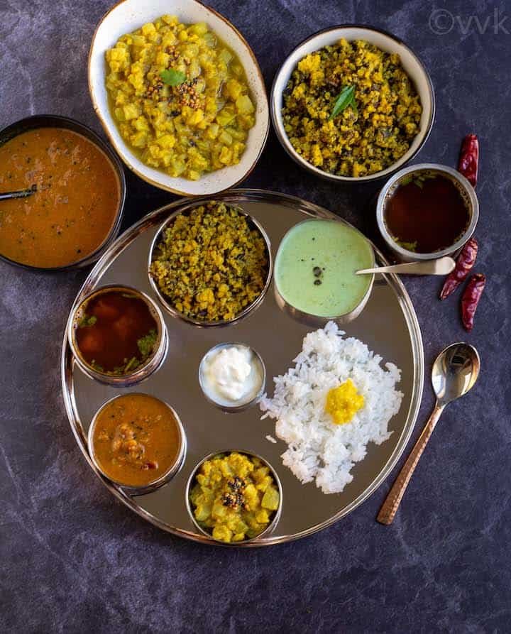 Traditional South Indian lunch served on banana leaf with rice, sambar, rasam, poriyal & sides