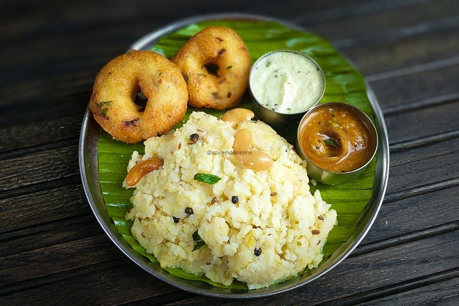 A plate of South Indian morning breakfast with idli, dosa, vada, sambar, and chutney.