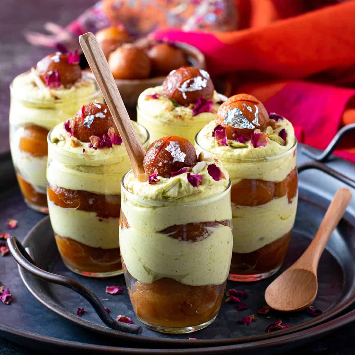A variety of desserts like ice cream, gulab jamun, and sweets served in bowls