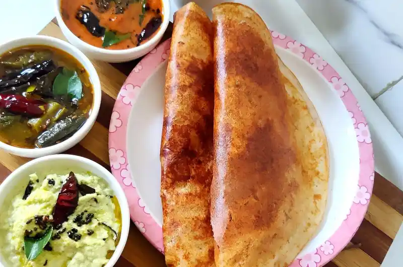 A selection of dosa varieties like plain dosa, masala dosa, and ghee roast served with chutney and sambar.