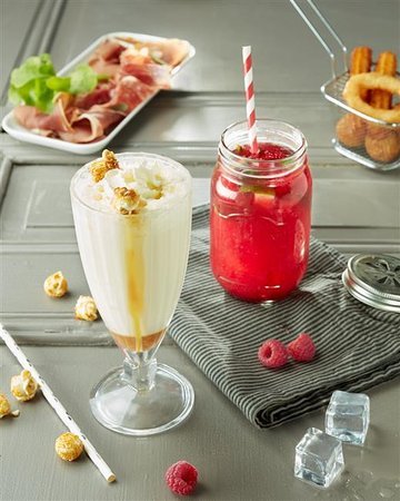 A variety of milkshakes and mojitos served chilled with fruits, mint, and ice